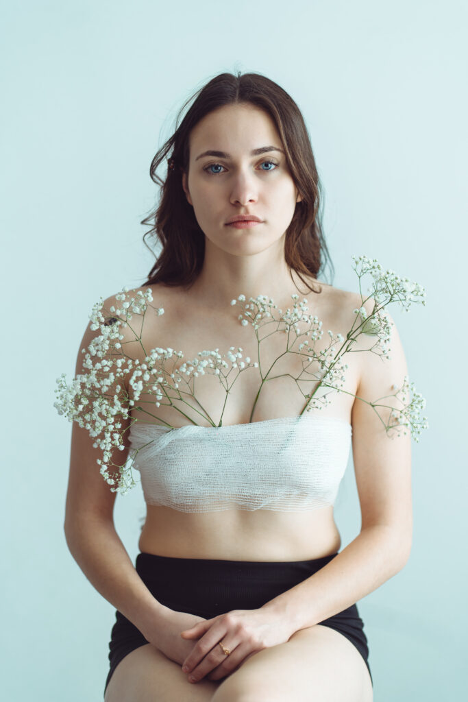 portret kobiety z kwiatami artystyczny portret kobiecy subtelna fotografia portretowa kobieta z delikatnymi kwiatami naturalne piękno romantyczny portret fotografia w ciepłym świetle kobieta trzymająca kwiaty