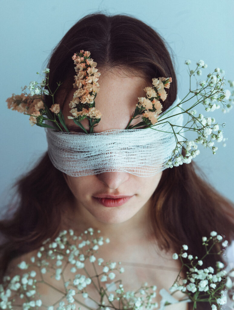 portret kobiety z kwiatami artystyczny portret kobiecy subtelna fotografia portretowa kobieta z delikatnymi kwiatami naturalne piękno romantyczny portret fotografia w ciepłym świetle kobieta trzymająca kwiaty